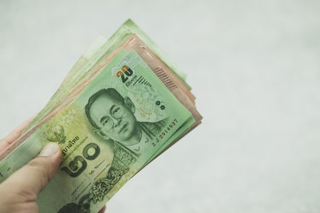 Thai currency banknote, twenty and one hundred, hand giving money. Money for paid legal debt.の写真素材
