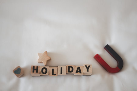Holiday word is written on wood block with star, heart and magnet. The concept of a holiday tourism campaign, use image for design in business or promotion for travel.の写真素材