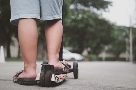 Close up of kid feet standing on a self-balanced scooter a back viewの写真素材