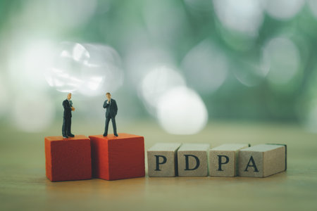 Miniature businessman standing on red wood block with wooden blocks with text PDPA. Data protection and secured internet access, cybersecurity, PDPAの写真素材