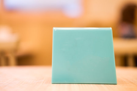 Mock up menu frame standing on wood table in bar restaurant cafe with space for textの写真素材