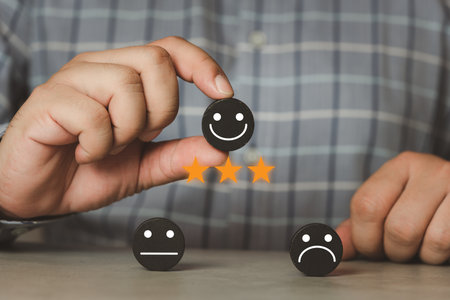 Customer services best excellent business rating experience. Satisfaction survey concept. Hand of man chooses a smile face on wood block circle. 3 star, Service provider satisfaction ratings.の写真素材