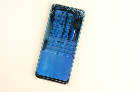 Glass smartphone display with cracks close up. Broken glass on a cell phone. A gadget that has...