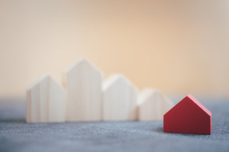 Single red house in front of the wooden house standing out from the crowd, real estate conceptの写真素材
