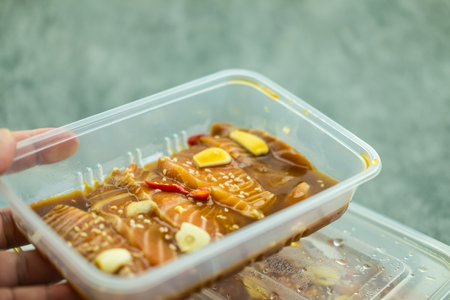 Fresh salmon raw pickled in shoyu sauce in box on handの写真素材