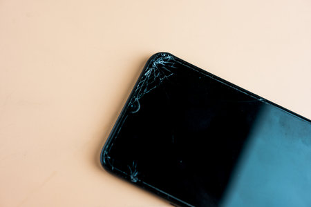 A smart phone with a cracked screen. Close upの写真素材