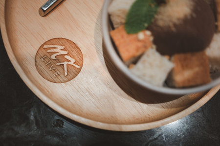 Samut Prakan, Thailand - November 19, 2022 : MK Live logo on wood saucer. MK restaurant is a sale food for healthy of various kinds for sukiyakiのeditorial素材