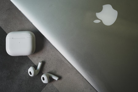 Bangkok, Thailand - November 21, 2022 : Apple AirPods 3 and charging case placed next to a silver...