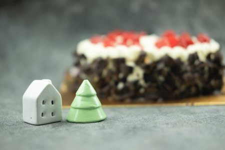 Mini ceramic Christmas tree and white house with cake background. Selective focusの写真素材