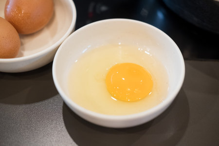 Raw eggs used when eating sukiyaki in white bowlの写真素材