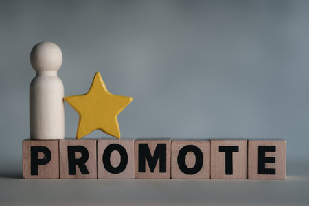 Wooden figures peg doll with star stand on block text of promote. Worker getting promotion, recognition, and respect of colleagues. An employee with job promotion or success.の写真素材