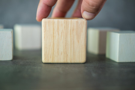 Hand holding big geometric real wooden cube for creative.