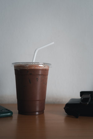 Ice cold coffee mocha in plastic glass on wood table at coffee shop.の写真素材