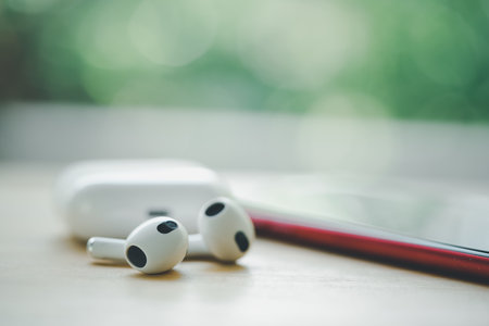 Bangkok, Thailand - December 17, 2022 : Close up Apple AirPods 3 on wood table.のeditorial素材