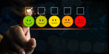 Client pressing smiley face emoticon on the digital touch screen for service evaluation. Customer satisfaction experience concept, Rating to service experience. Marketing research, satisfaction user.の写真素材