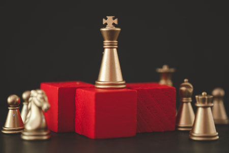 Concept of leadership. Close up the golden king chess on the top and stand on a red podium....