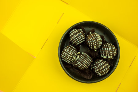 Delicious chocolate corn balls topped with sauce chocolate and sauce vanilla opened from a yellow...