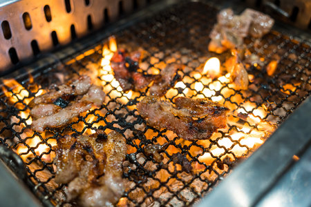 Grilled beef with flame, Yakiniku food barbecue and grilled over charcoal on stove in restaurantの写真素材
