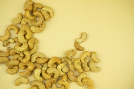 Roasted cashew nuts on yellow background. Minimalist food photography styleの写真素材