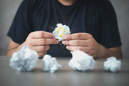 Hand holding the best of crumpled paper with Illustration of light bulb inside. Inspiration and new idea concept. Concept of idea with white crumpled paperの写真素材