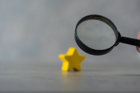 A black magnifying glass with a yellow star. The concept of finding the star, find a new actor....
