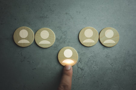 Hand selective to human icon on wood block which is among staff icons for human development recruitment leadership. Human resource management and recruitment business concept.の写真素材
