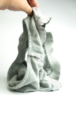 An old used wrinkled cotton grey dirty male underpants, for a household advertising presentation.