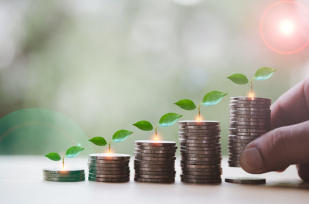 Stacking of money coins with plants growing on top and hand put a one of stack of coins, concept idea investment, funds and step to keep money. Saving and investment or Future financial planningの写真素材