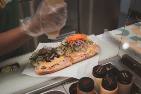 Bangkok, Thailand - February 16, 2023 : Subway staff is cooking sandwich at Subway shop in Thailand. Subway is an American fast food restaurant franchise that sells sandwiches and salads.のeditorial素材