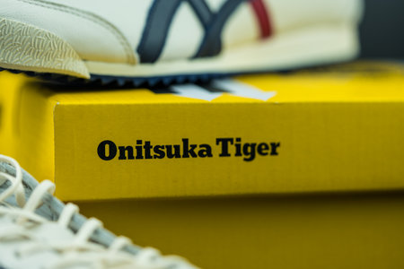 BANGKOK, THAILAND - FEB 16, 2023: Close up a logo of Onitsuka Tiger on a yellow paper box. The shoes made by Onitsuka Tigerのeditorial素材