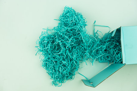 Pile of shredded paper blue color like a bird nest for filler for gifts. Close up. Used to protect fragile objects while in transport.の写真素材