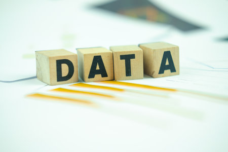 The word Data, alphabet on wooden cubes on paper graph background. Research study or information analysis, facts and knowledge for education or business.の写真素材