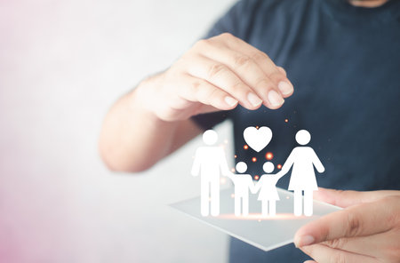 Cutout paper chain family with the protection of cupped hands, the concept for security and care. The insurer protecting a family with his handsの写真素材