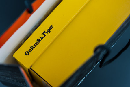 BANGKOK, THAILAND - MAR 4, 2023: Close up a logo of Onitsuka Tiger on a yellow paper box. The shoes made by Onitsuka Tigerのeditorial素材