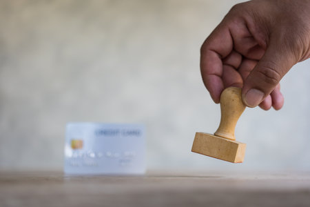 Hand use rubber stamp and with blur background white credit card. The concept of approved credit cardの写真素材