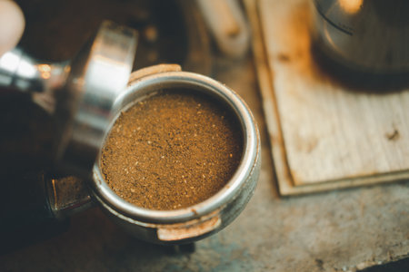 Barista making coffee with manual presses ground coffee using tamper on the counter bar at the coffee shopの写真素材
