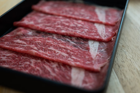 Fresh premium quality beef raw sliced with marbled texture on black trayの写真素材