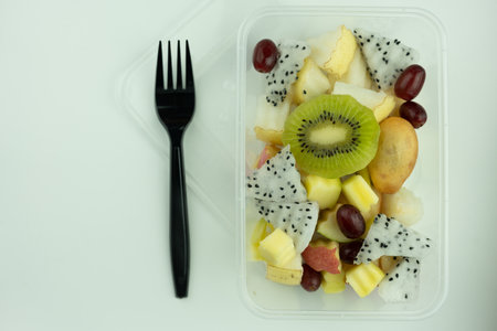 Mix of tropical fruit served in a plastic box. Freshly fruit salad. Food delivery. Healthy foodの写真素材