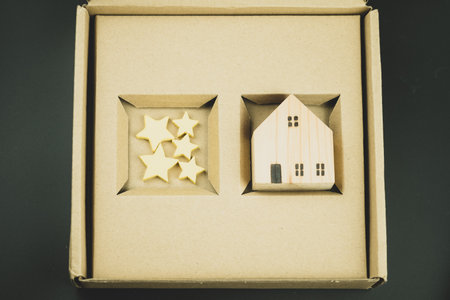 Five star rating for house. Wood home model and yellow star on brown paper box or business real estate success management concept. The best home and offer house. Real estate success management conceptの写真素材