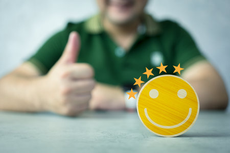 Customer services best excellent business rating experience. The customer hand gives a smile face icon on the wood circle cube block. Customer services best excellent business rating experienceの写真素材