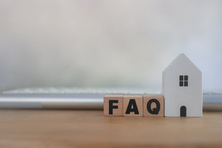 FAQ customer management analysis service for home concept, help desk and call center operator. Wooden blocks with the word FAQ place with white home and key board on the tableの写真素材