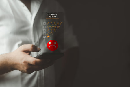 Man showing sign choosing sadness emotion face screen and one star. Unhappy man client with sad use on a smartphone gives bad reviews, bad service and bad quality, low rating.の写真素材