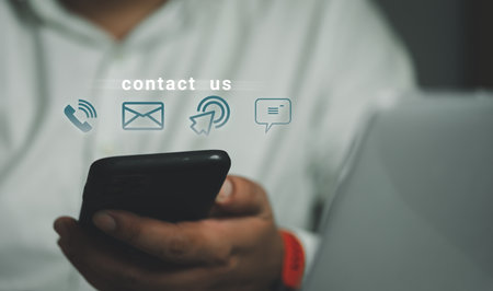 Hand of a man holding a mobile smartphone with the icon customer support. Contact us concept....