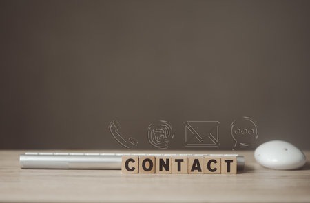 Wood block with text of CONTACT and transparent a symbol telephone, mail, address and chat with keyboard and mouse. Website page contact us or various contact options concept. Customer support hotlineの写真素材