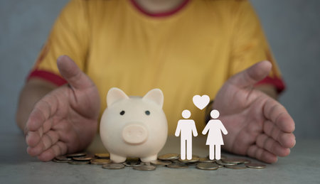 Man takes a position to protect on the piggybank and icons paper life partner in hand. Superannuation, investment concept. The new couple. Saving for stability family reserveの写真素材