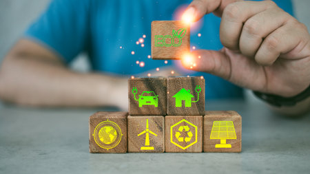 Hand of a man arranging wood block with renewable energy icon. Idea for environmentally conscious,...