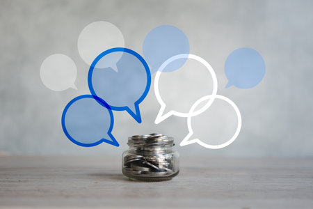 Many of empty speech bubble icon above of coins in a glass jar on wood table for many any of objective. The concept of saving to pay the moneyの写真素材