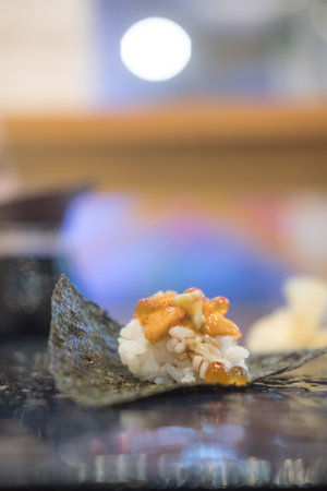Unwrapped uni and salmon egg sushi in black tray on the table. Close upの写真素材