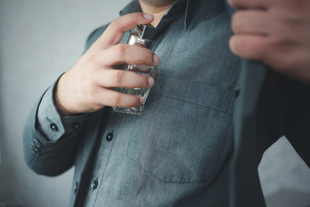 Handsome man using perfume at home in the morningの写真素材