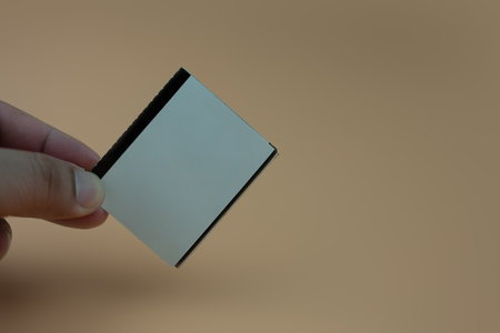 Hands holding an empty white a paper movie ticket. You can create your own design.